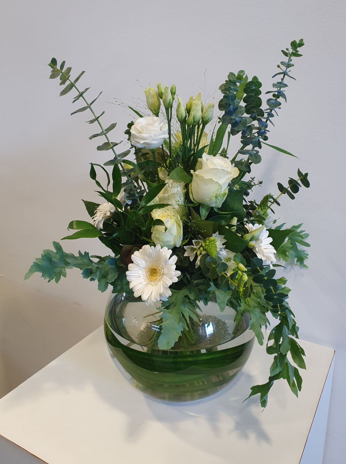 Glasvase mit weißen saisonalen Schnittblumen