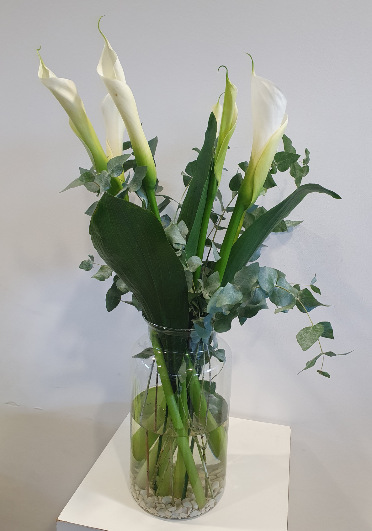 Glasvase mit 5 weißen Calla und passendem  Schnittgrün