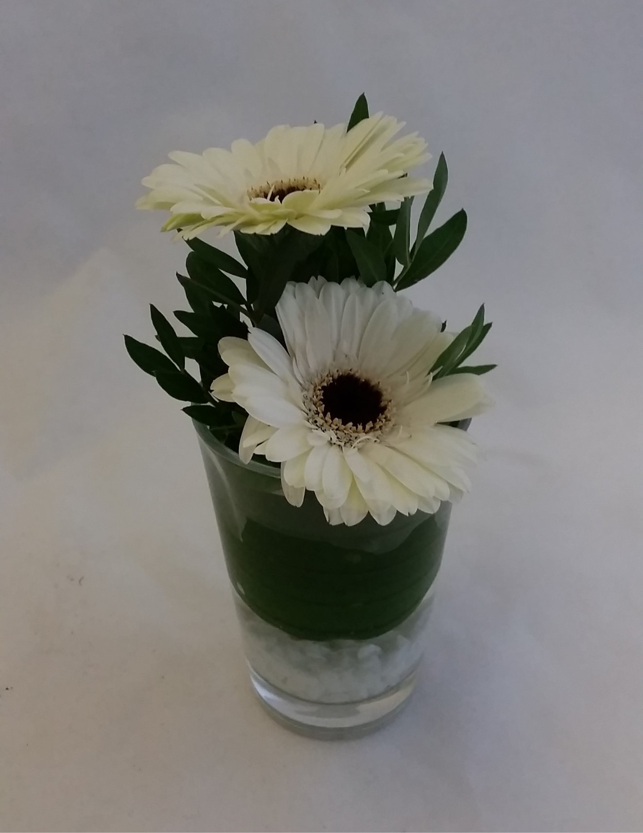 Tischglas mit weißen Schnittblumen